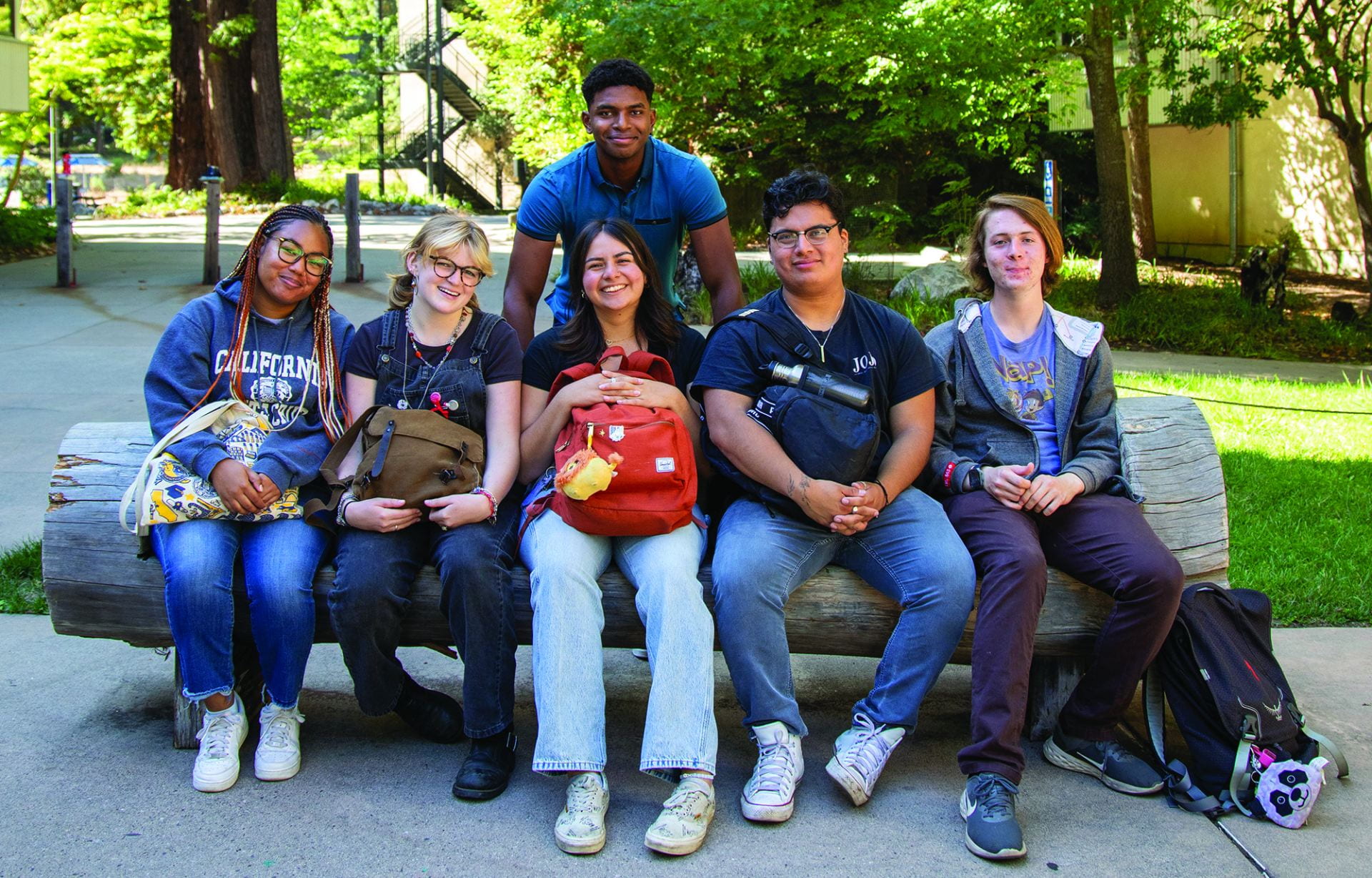 Six students sitting on a bench at UC Santa Cruz, posing for a photo.